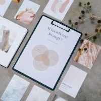 Aesthetic flat lay of branding and design documents on textured surface.